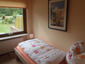 A bedroom with a bed, a window, a radiator, and a framed picture on the wall. - Ferienhaus by Interhome (Witzeeze)