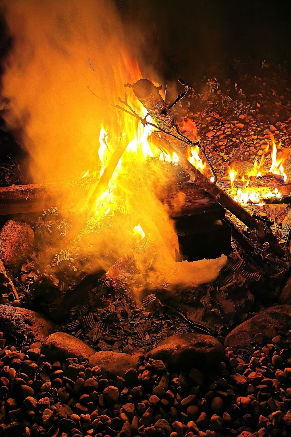 Ein Lagerfeuer mit Baumstämmen und Steinen darum.