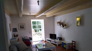 Ein Wohnzimmer mit einer Couch, einem Couchtisch, einem Fernseher und einem Bücherregal.