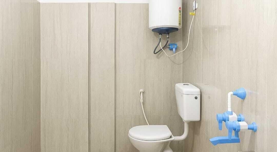 Un baño con inodoro, calentador de agua y grifo azul.