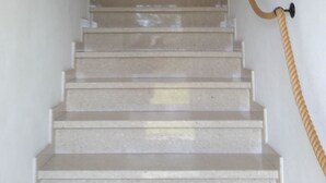 Eine Treppe mit Geländer und einem an der Wand befestigten Schild.