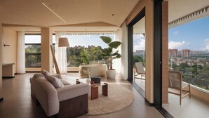 Ein modernes Wohnzimmer mit einer Couch, einem Couchtisch und Topfpflanzen.