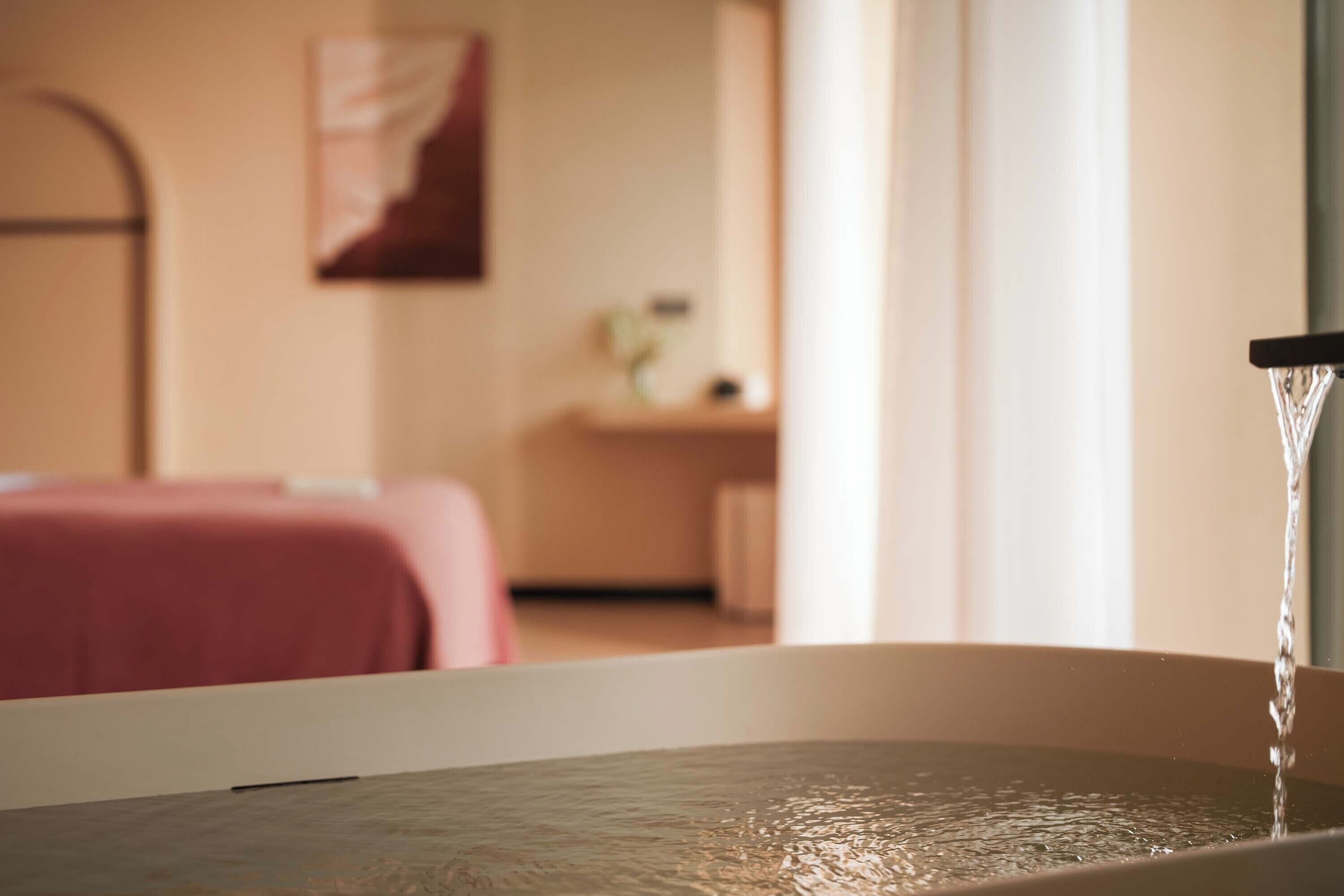 A bathroom with a bathtub, a sink, and a mirror.
