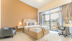 Una camera da letto moderna con un letto grande, una scrivania e vista sulla città.