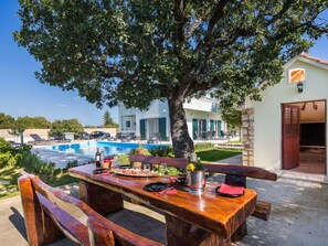 Outdoor dining - Ferienvilla mit Kamin am Waldrand by Interhome (Katuni)