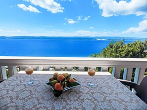 A balcony with a table, two wine glasses, and a fruit arrangement. - mit zwei Schlafzimmern und Pool by Interhome (Medici)