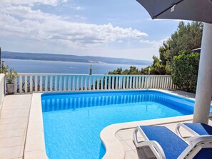 A swimming pool with a view of the sea, a white railing, and a few lounge chairs. - mit zwei Schlafzimmern und Pool by Interhome (Medici)