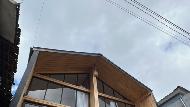 A multi-story building with a wooden upper floor and a brick lower floor. - Rees Cabin & Homestay (Dieng Kulon)