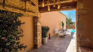 A covered patio with a pool, outdoor seating, and potted plants. - Villa Cava – Villa with a private pool in Crete (Xirostérnion)