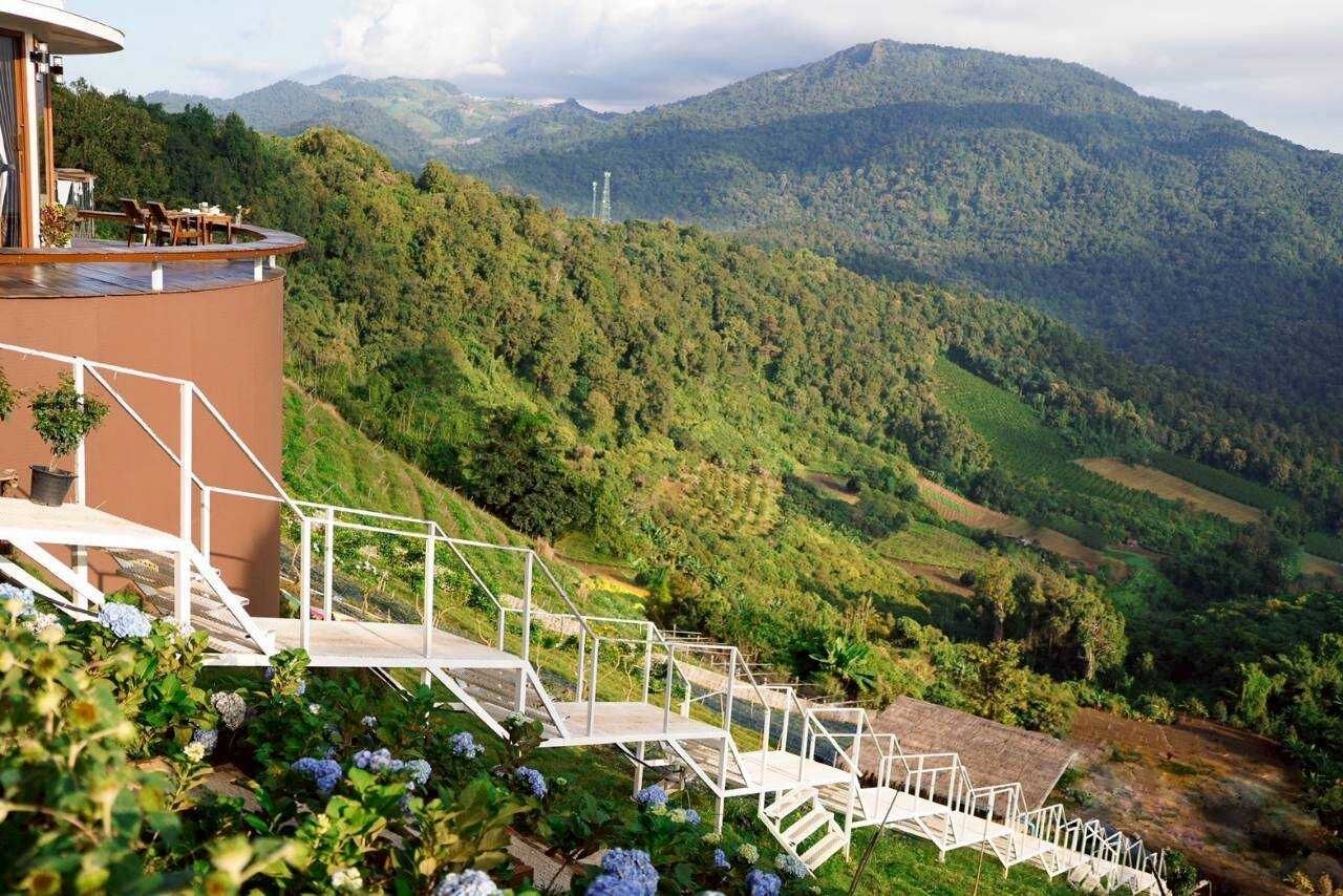 Un hôtel doté d’une terrasse offrant une vue sur un paysage montagneux.