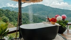 A bathtub with a view of a mountainous landscape.