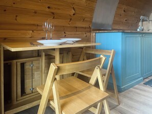 A wooden kitchen with a blue cabinet, a wooden table, and two chairs. - 1 bedroom accommodation in Dalton-in-Furness (Dalton-in-Furness)
