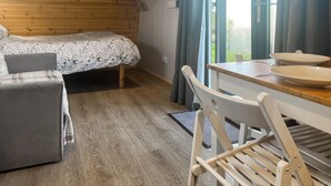Una habitación acogedora con una cama, una mesa con platos y una silla.