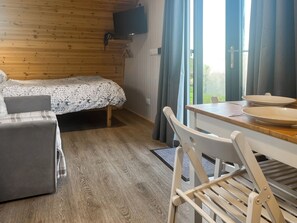 Ein gemütliches Zimmer mit einem Bett, einem Tisch mit Tellern und einem Stuhl.