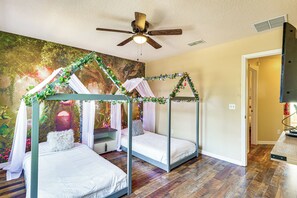 A room with three bunk beds, a ceiling fan, a mural, and a wooden floor. - 9 Mi to Disney: Davenport Home w/ Pool & Game Room (Davenport)