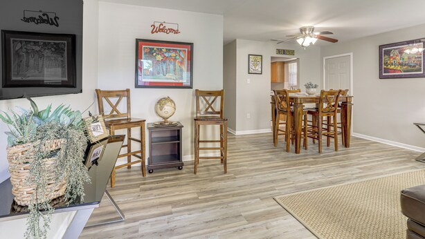 A spacious living area with a dining table and chairs, a globe on a side table, and framed artwork on the walls. - 1 Mi to LSU, Tiger Stadium! Lovely Home w/ Parking (Baton Rouge)
