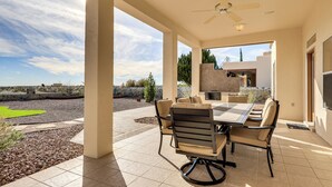An outdoor patio with a table and chairs, a ceiling fan, and a view of the surrounding landscape. - Golf, Hike & Stargaze: Quiet Home in Las Cruces (Las Cruces)