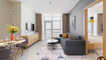 Apartment, Balcony, City View | Living area | 65-inch Smart TV with cable channels