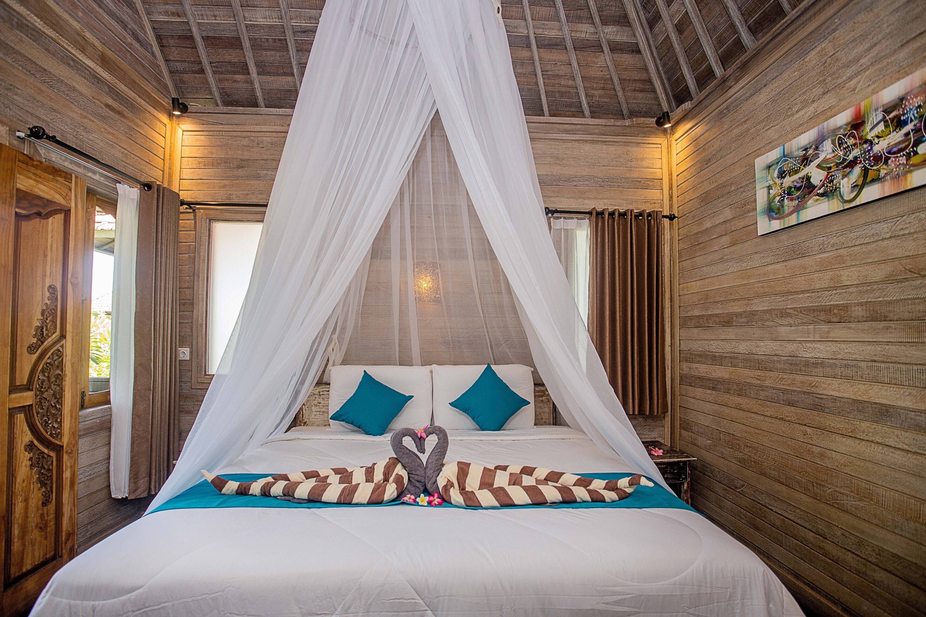 A bed with a canopy, two pillows, and a decorative pillow arrangement.