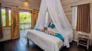 A bedroom with a canopy bed, wooden flooring, and a balcony with a view of greenery. - D’Gume Villas Lembongan by Bali Cabin (Lembongan Island)