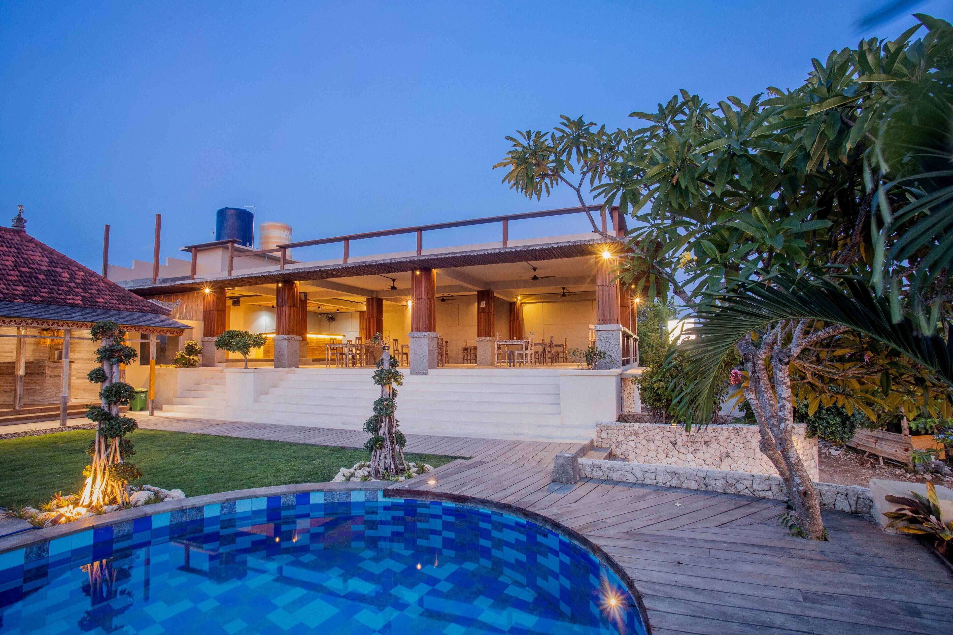 A modern house with a swimming pool, outdoor seating area, and a well-maintained garden.