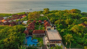 An aerial view of a resort with multiple bungalow-style buildings, a swimming pool, and a view of the ocean. - D’Gume Villas Lembongan by Bali Cabin (Lembongan Island)