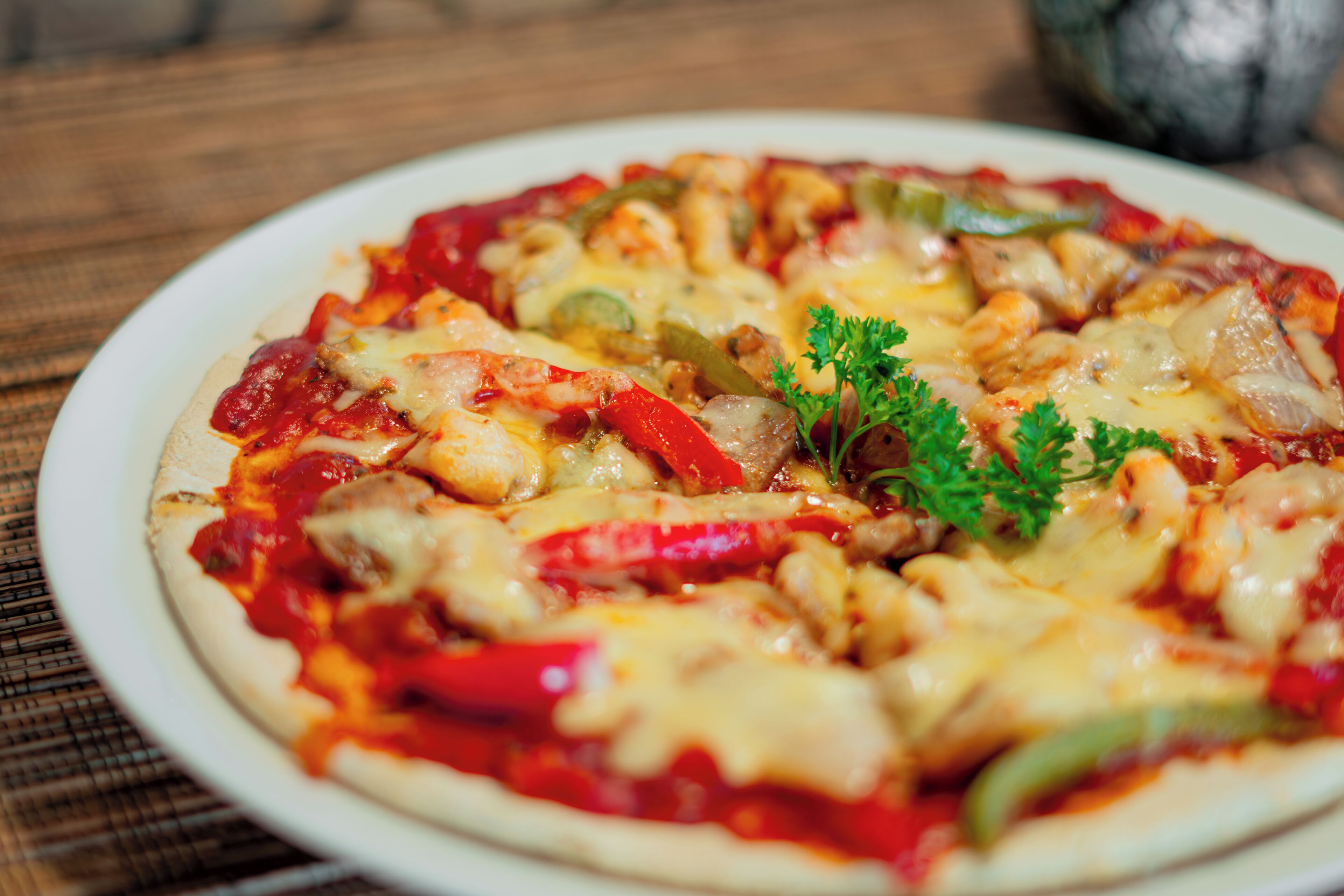 A pizza with various toppings on a white plate.