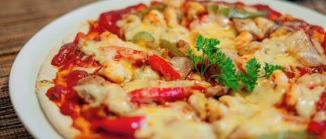 A pizza with various toppings on a white plate.