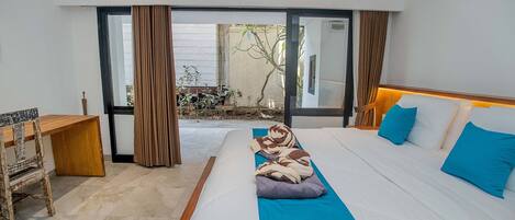 Habitación de hotel con una cama grande, un escritorio y vistas al exterior.