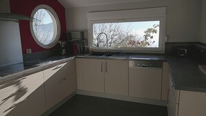 A kitchen with a window, a sink, and cabinets.