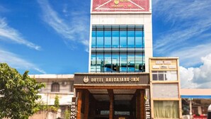 A hotel with a modern glass facade and a prominent sign for Hotel Aalcajars Inn. - Aalcajars Inn (Patna)