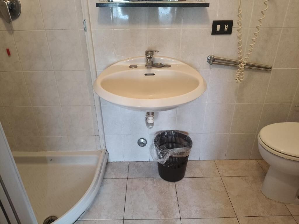 A bathroom with a sink, toilet, and shower.
