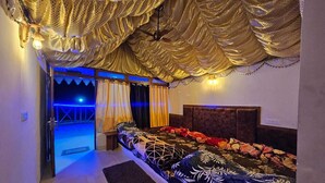 Ein Schlafzimmer mit Bett, Vorhängen und Deckenventilator.