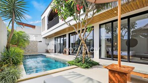 A modern house with a swimming pool, large windows, and a wooden deck. - Darani Villa by Kozystay - Ungasan (Ungasan)