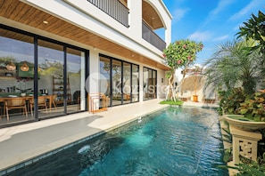 A modern house with a swimming pool, large windows, and outdoor furniture. - Darani Villa by Kozystay - Ungasan (Ungasan)