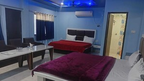 A bedroom with a bed, a desk, and a chair. - The Bhuwan Heights Inn (Satna)