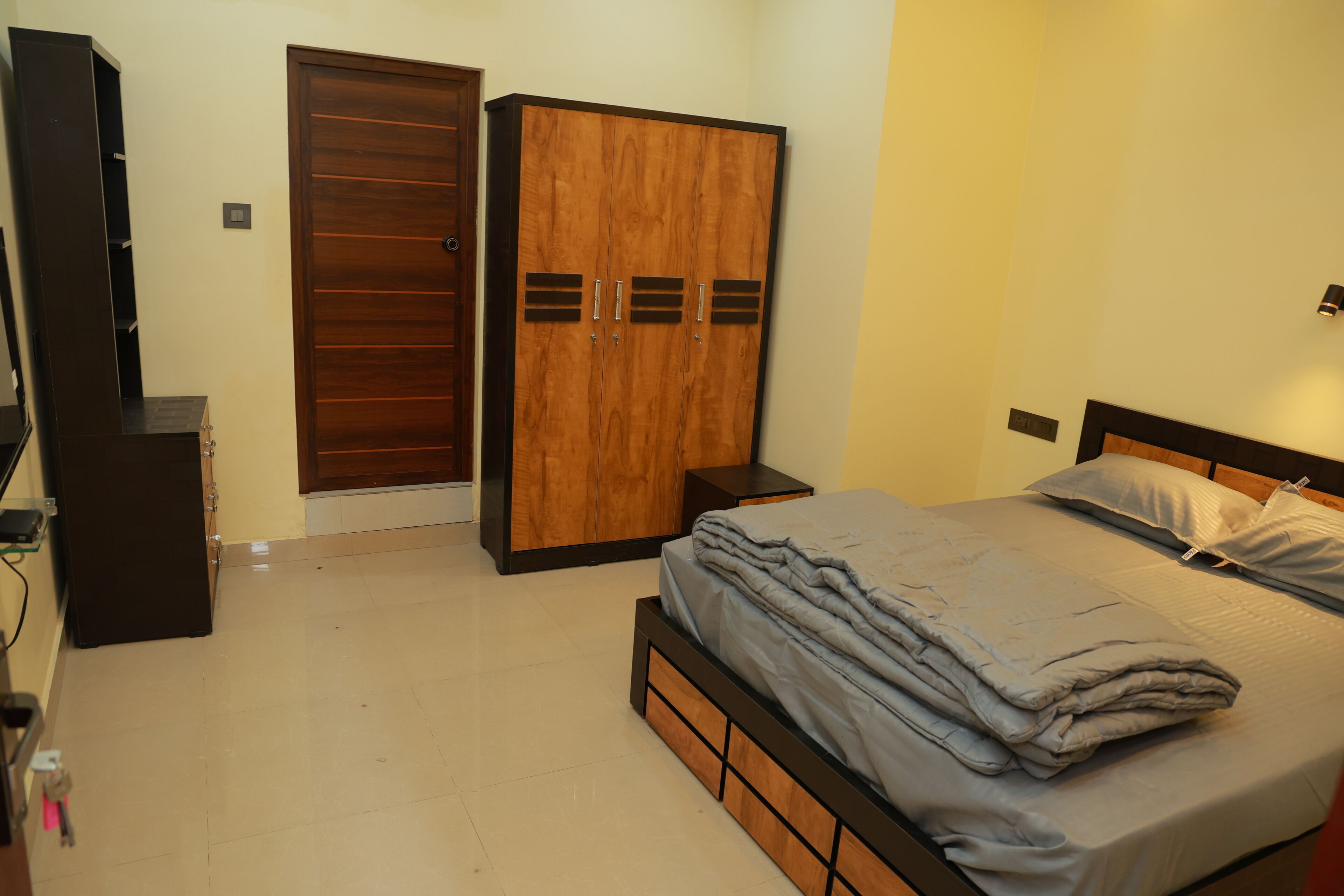 Un dormitorio con cama, armario y mueble para televisión.