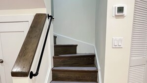 Una escalera con escalones de madera y paredes blancas.