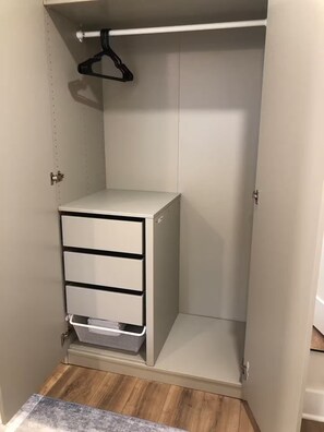 A walk-in closet with a white dresser, a hanging rod, and a mesh storage basket. - 2-Story Garden Loft with Parking - 1200 Sqft, 2BR/3Qeen Beds, Walk to Metro, Zoo (Washington)