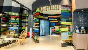 Un interior moderno con una zona de estar circular, separadores de vidrio y diversos muebles de almacenamiento de colores.