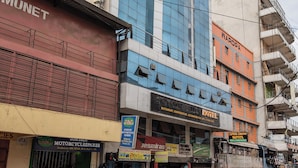A hotel with a modern facade, multiple floors, and a variety of signage including a prominent 'HOTEL' sign. - Capital Comfort Hotel (Nairobi)