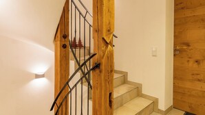 Una escalera con barandillas de madera y baldosas color beige.