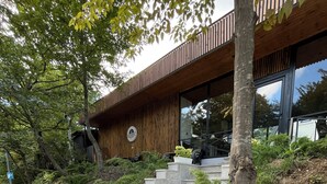 A modern building with a wooden facade and a sign indicating a conference center. - AFORREST FAMILY RESORT (Qusar)