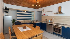 Eine moderne Küche mit blauen Schränken, einem Holzespeisetisch und einem eingebauten Backofen.