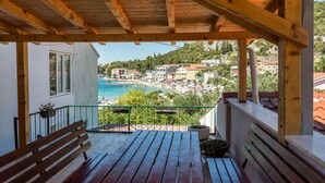 Eine Holzterrasse mit Blick auf einen Strand und Gebäude.