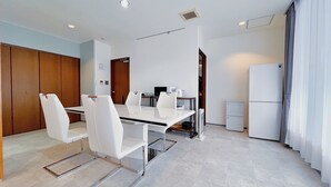 A modern kitchen with a dining area, white appliances, and a large window with curtains. - Fierement inn (Sapporo)