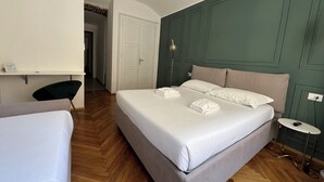 A hotel room with a large bed, a bedside table, a chair, and a desk. - Turin Central Suite (Turin)