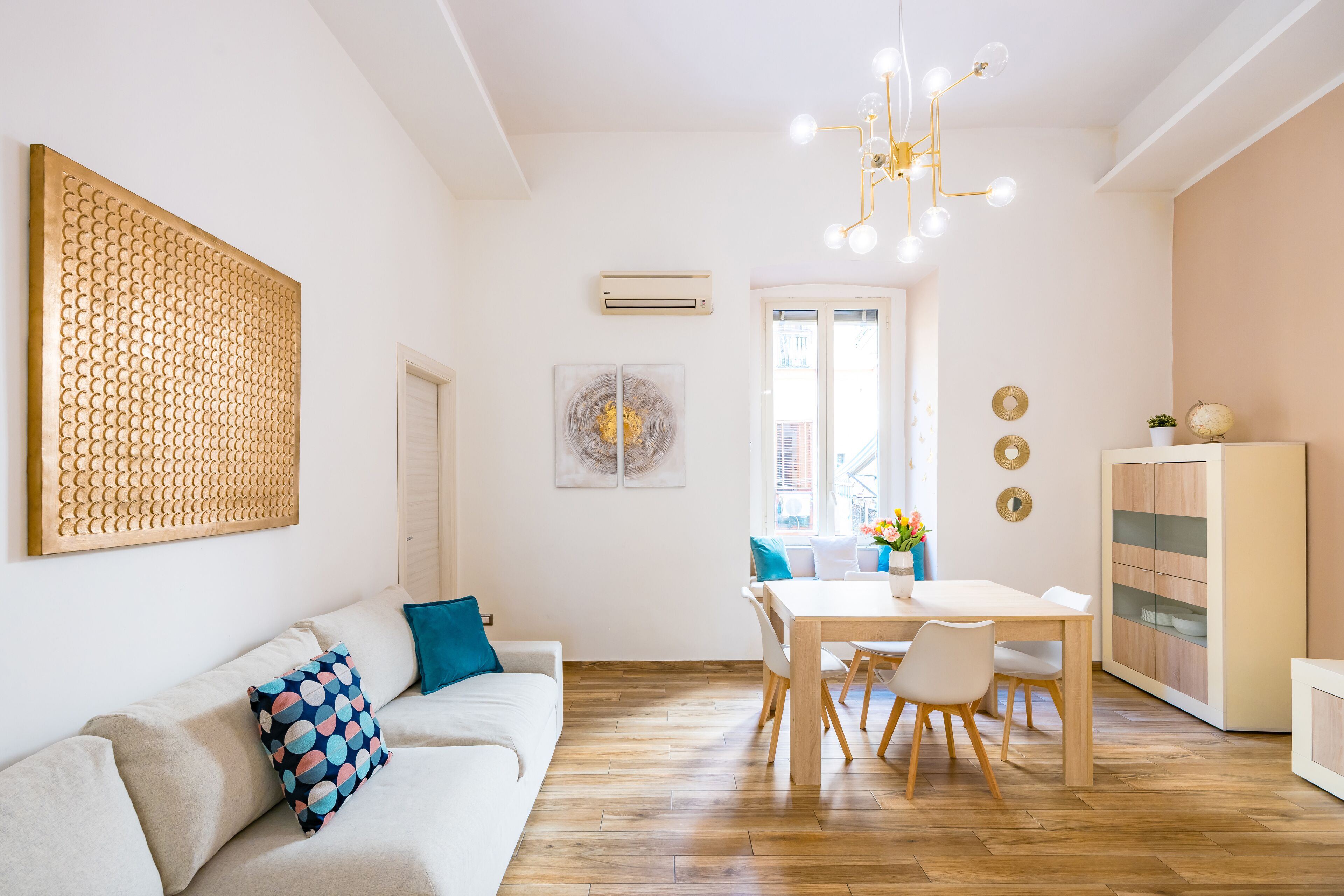 Ein modernes Wohnzimmer mit einer Couch, einem Esstisch und einer Küchenzeile.