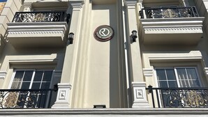 Un immeuble doté d’une entrée centrale, de balcons richement décorés et d’une enseigne indiquant « Ocean Regency ».