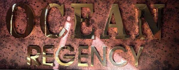 Une enseigne avec les mots « OCEAN REGENCY » écrits en grandes lettres métalliques.